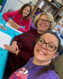 Service user Catherine smiling in between two other service users